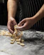 a man is making pasta on a table