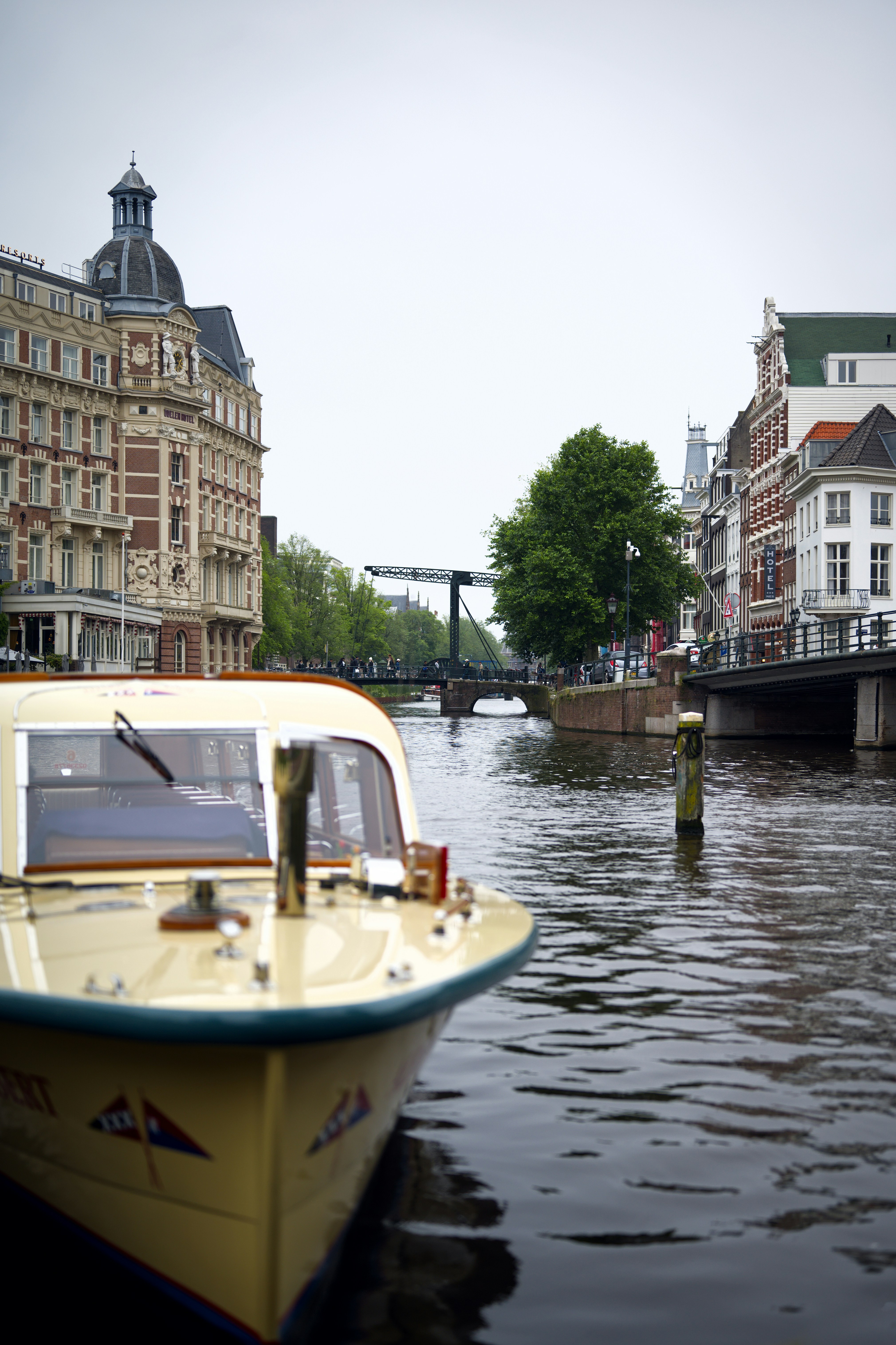 Ein gelbes Boot, das neben einer Brücke einen Fluss hinuntertreibt