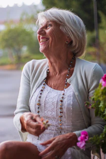 a woman sitting on a bench holding a flower