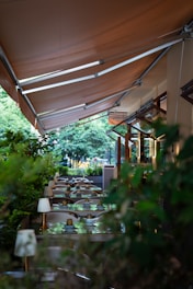 a restaurant with tables and chairs under a canopy