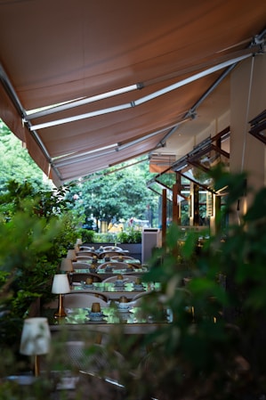 a restaurant with tables and chairs under a canopy