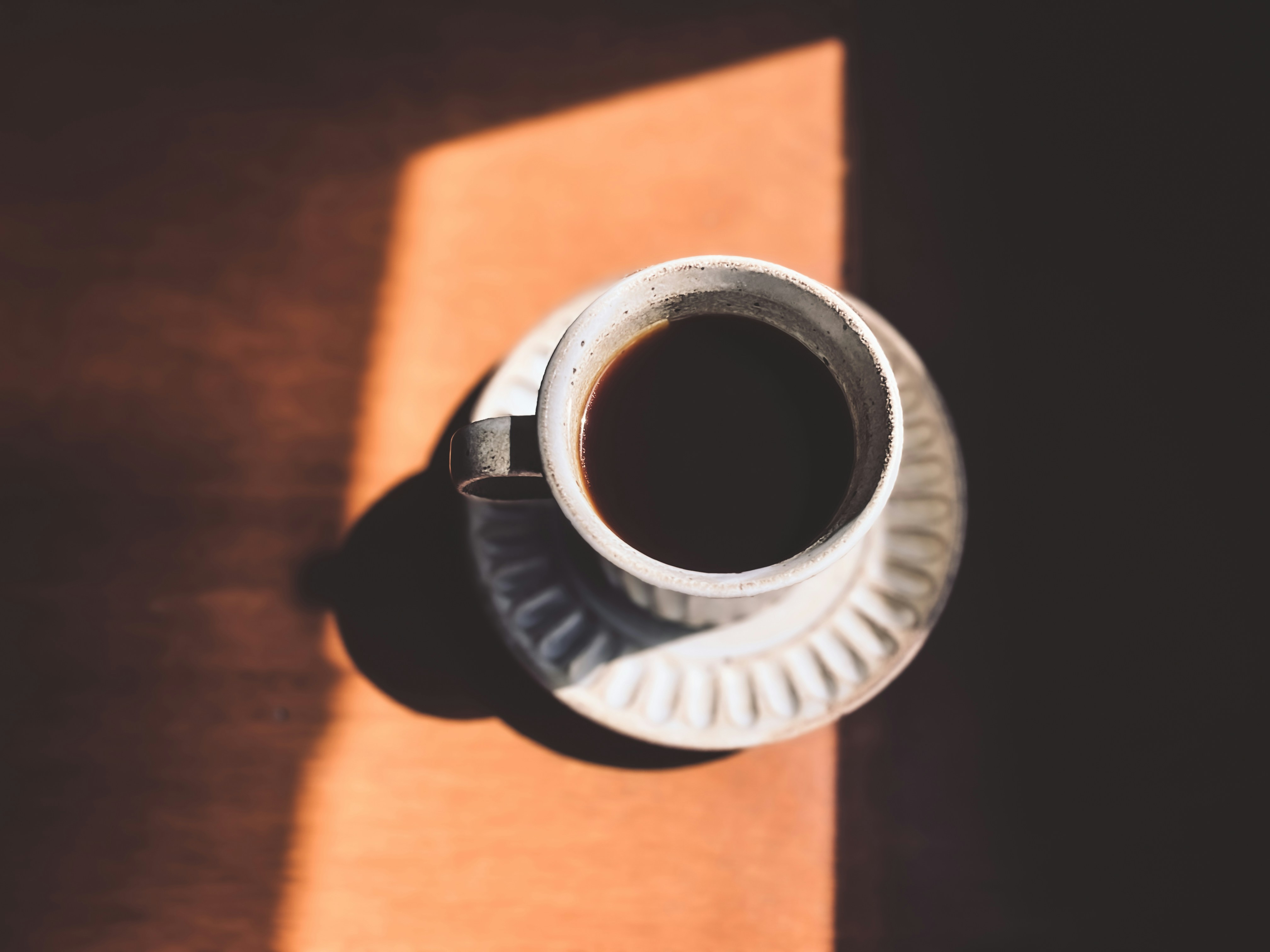 a cup of coffee sitting on top of a wooden table