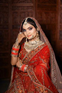 a woman in a red and gold bridal outfit
