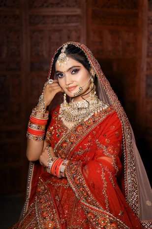 a woman in a red and gold bridal outfit