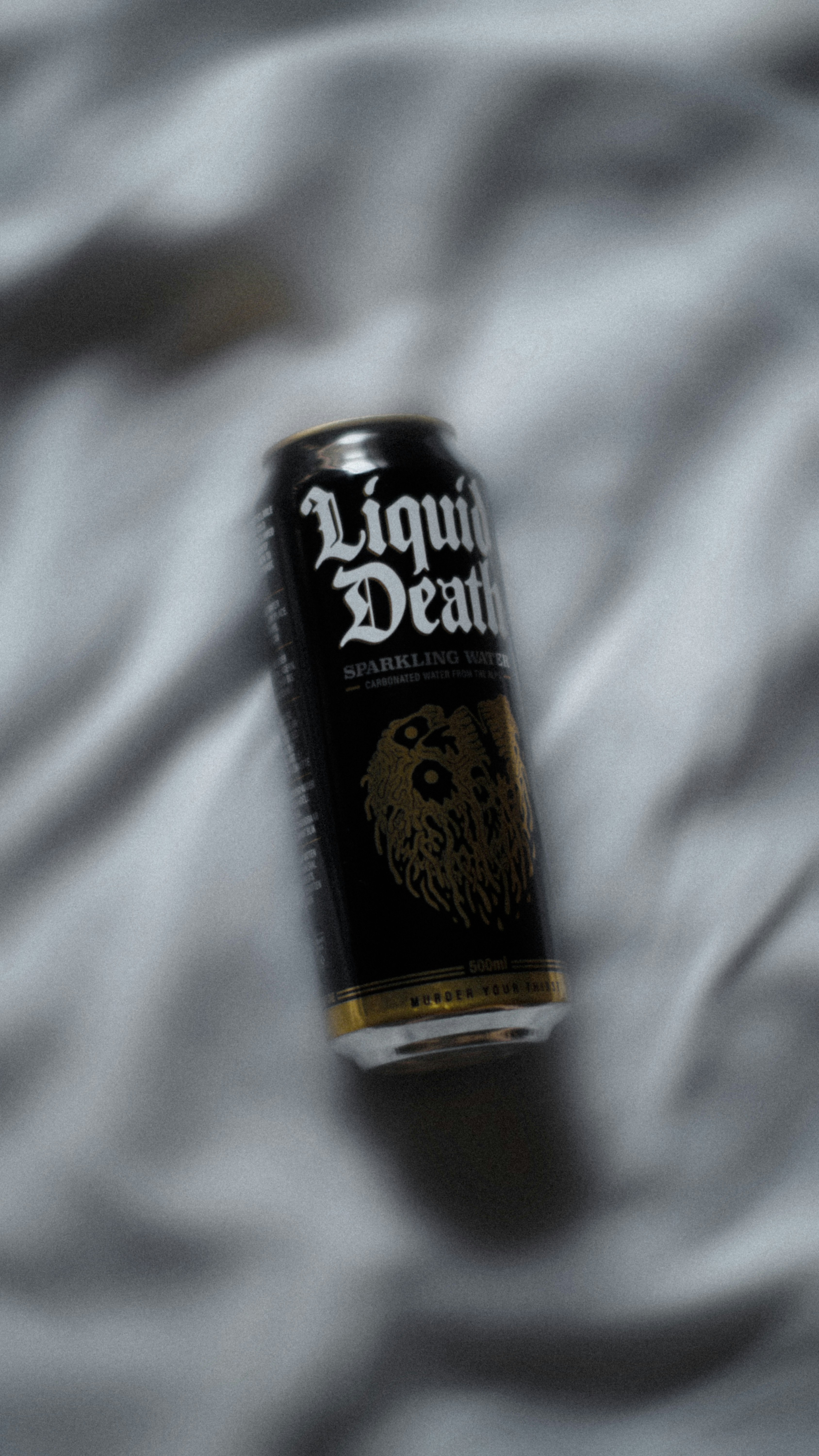 a can of liquid that is laying on a bed