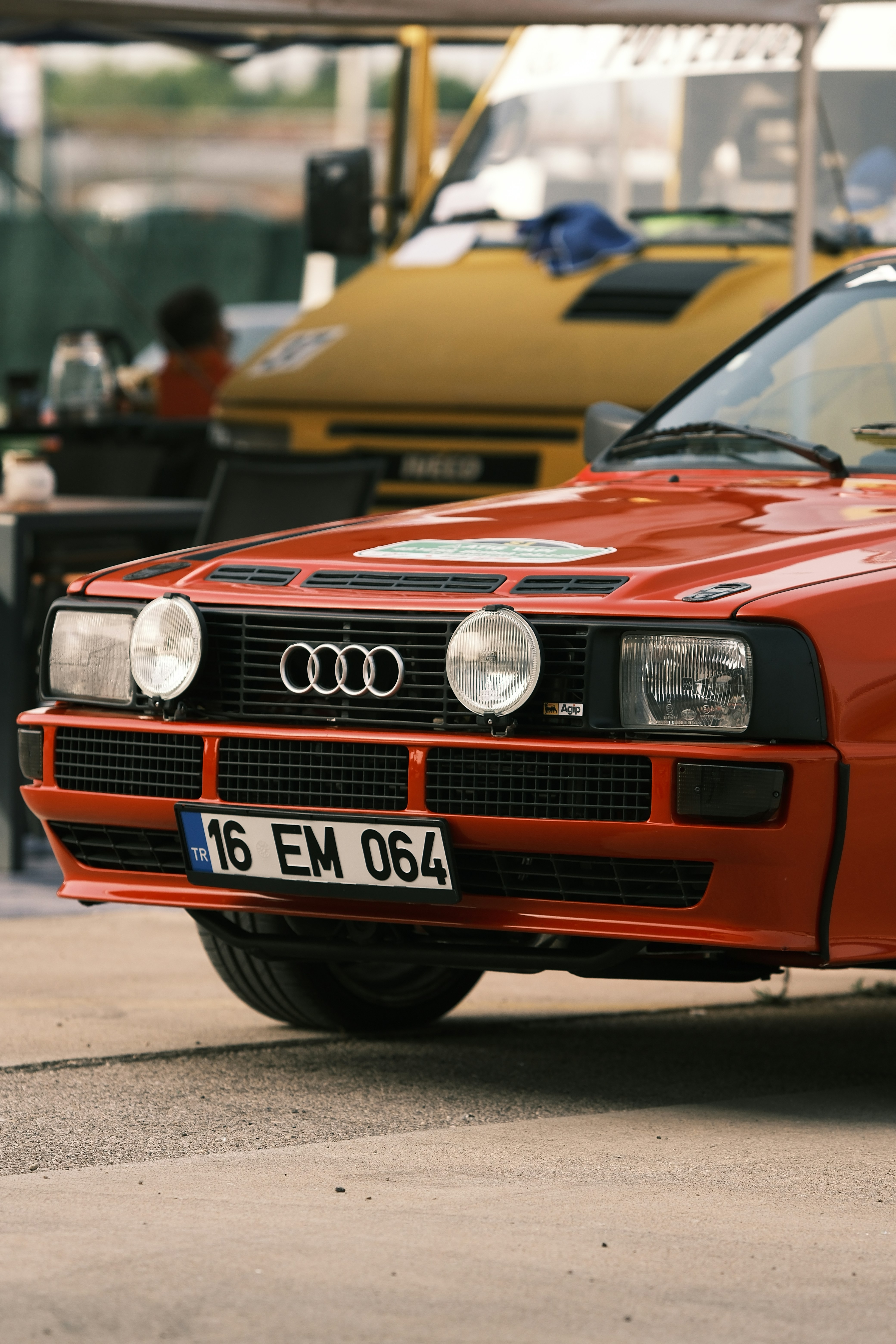 a red car parked in a parking lot next to other cars