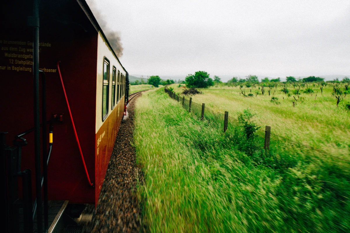 Train traveling through lush green European countryside
