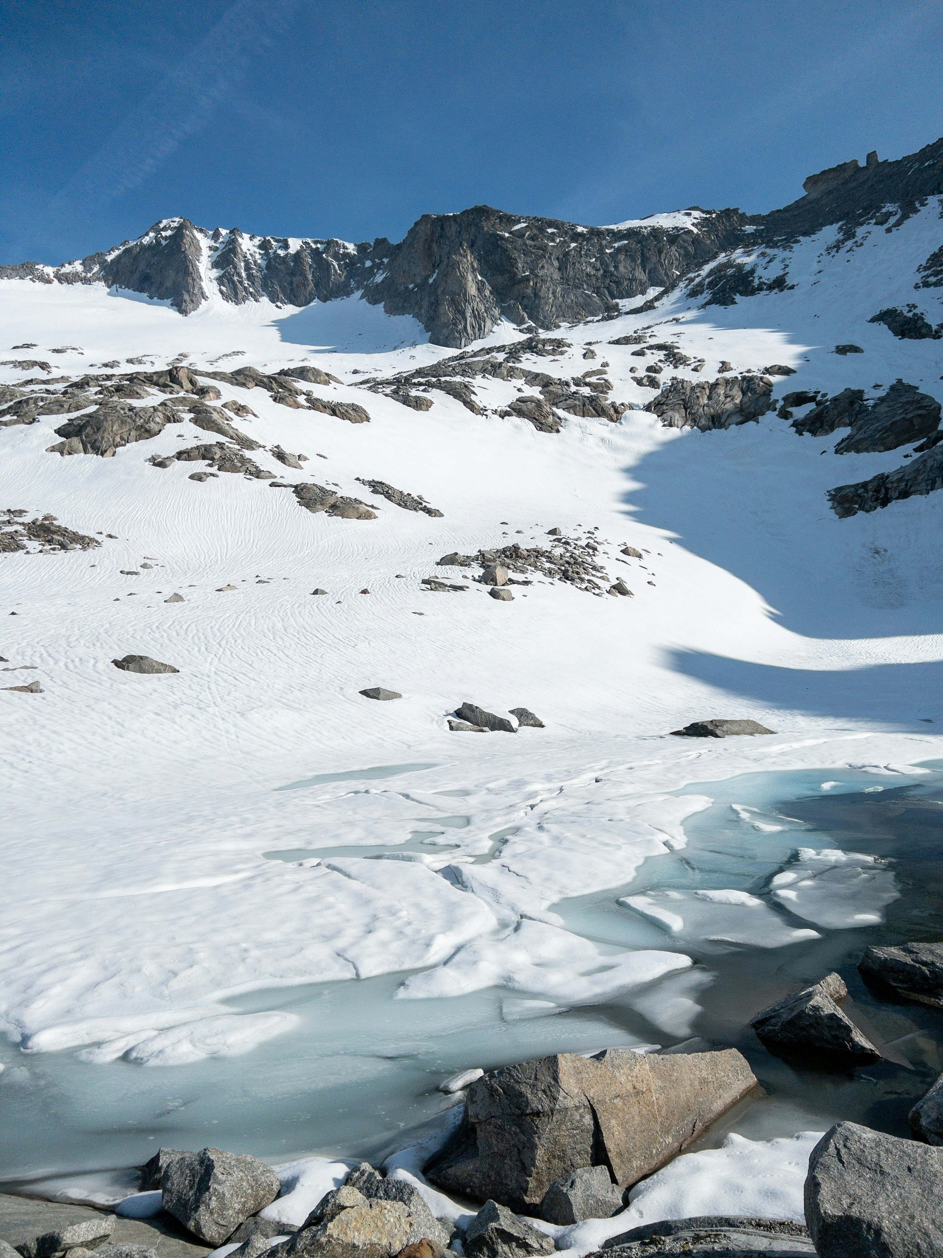 a snow covered mountain with rocks and water