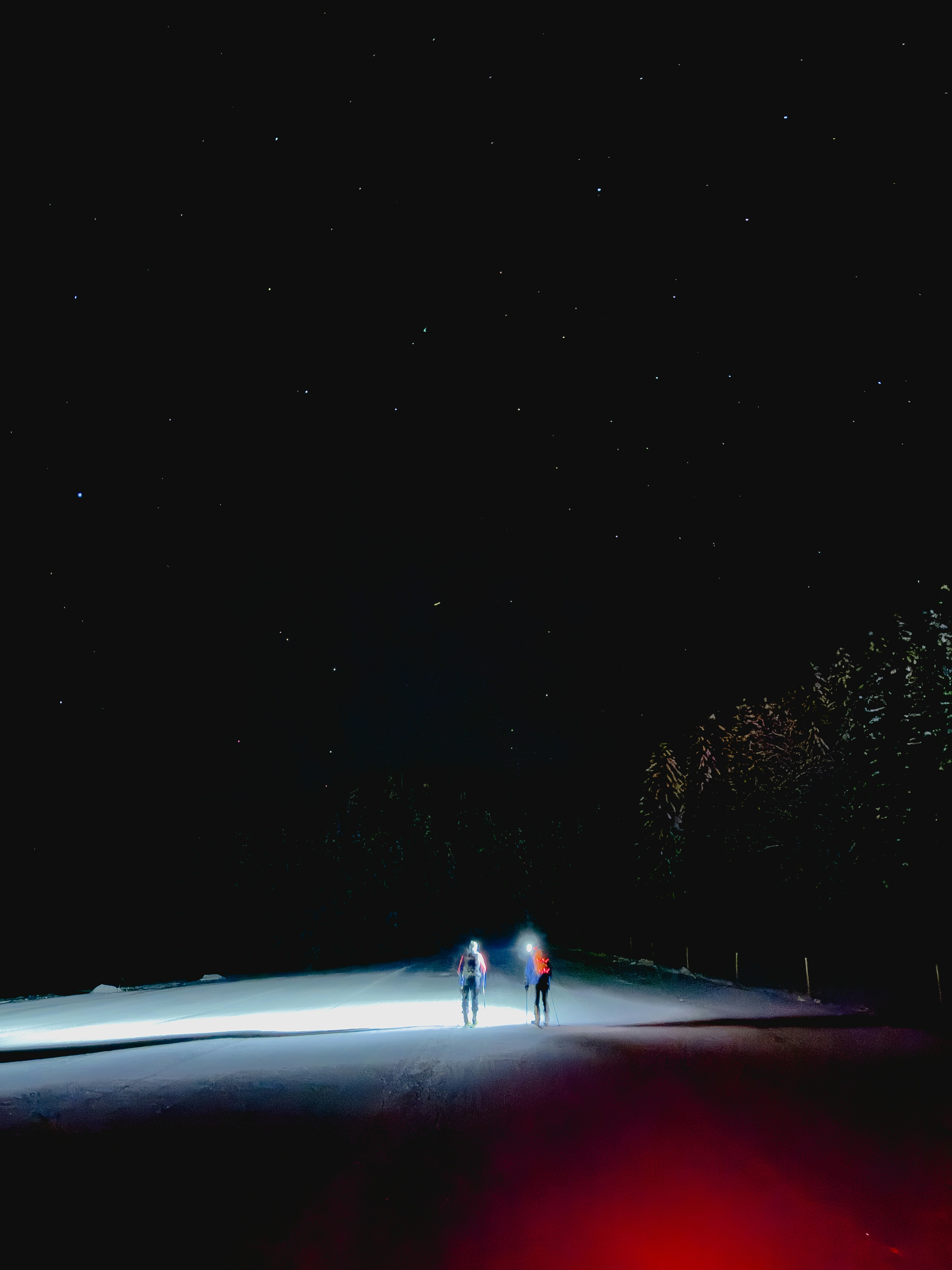 two people standing in the snow at night