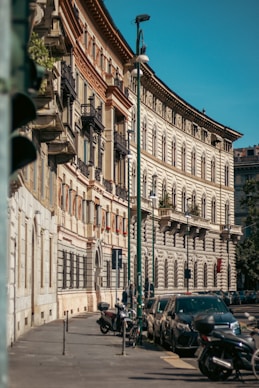 a row of parked cars sitting next to a tall building