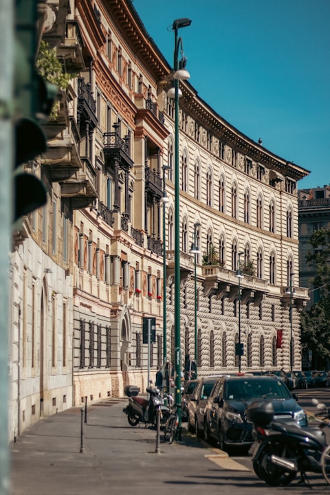 a row of parked cars sitting next to a tall building