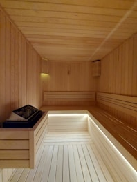 a wooden room with a bench and a light