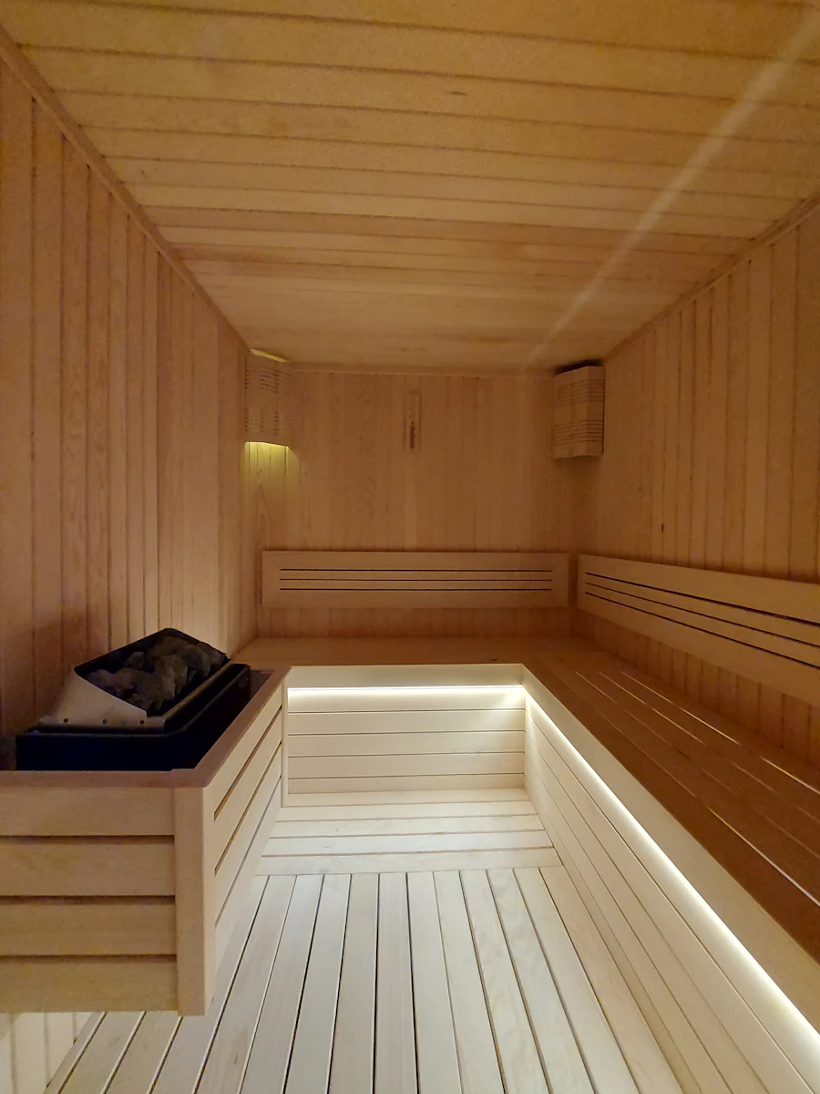 Sala de vapor con bancas de madera y luz baja