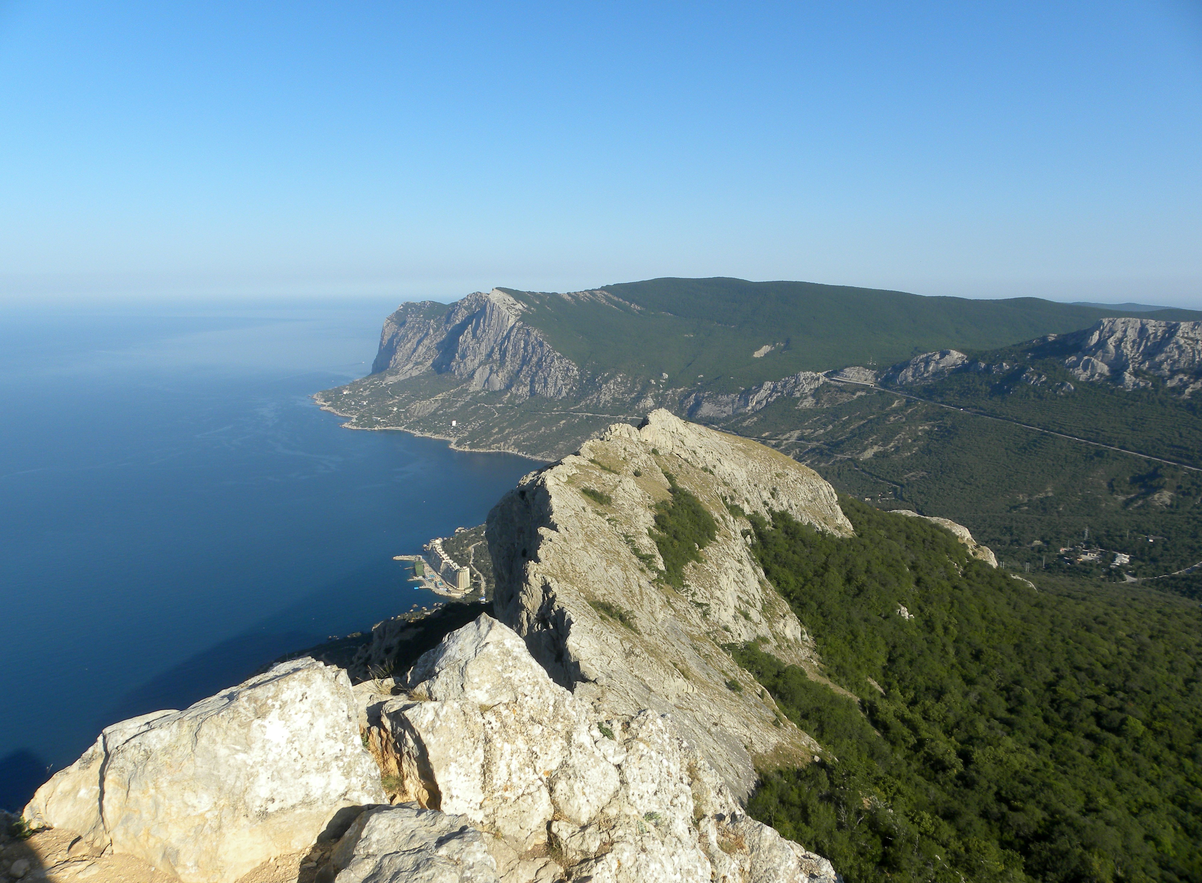 a man standing on top of a cliff next to the ocean