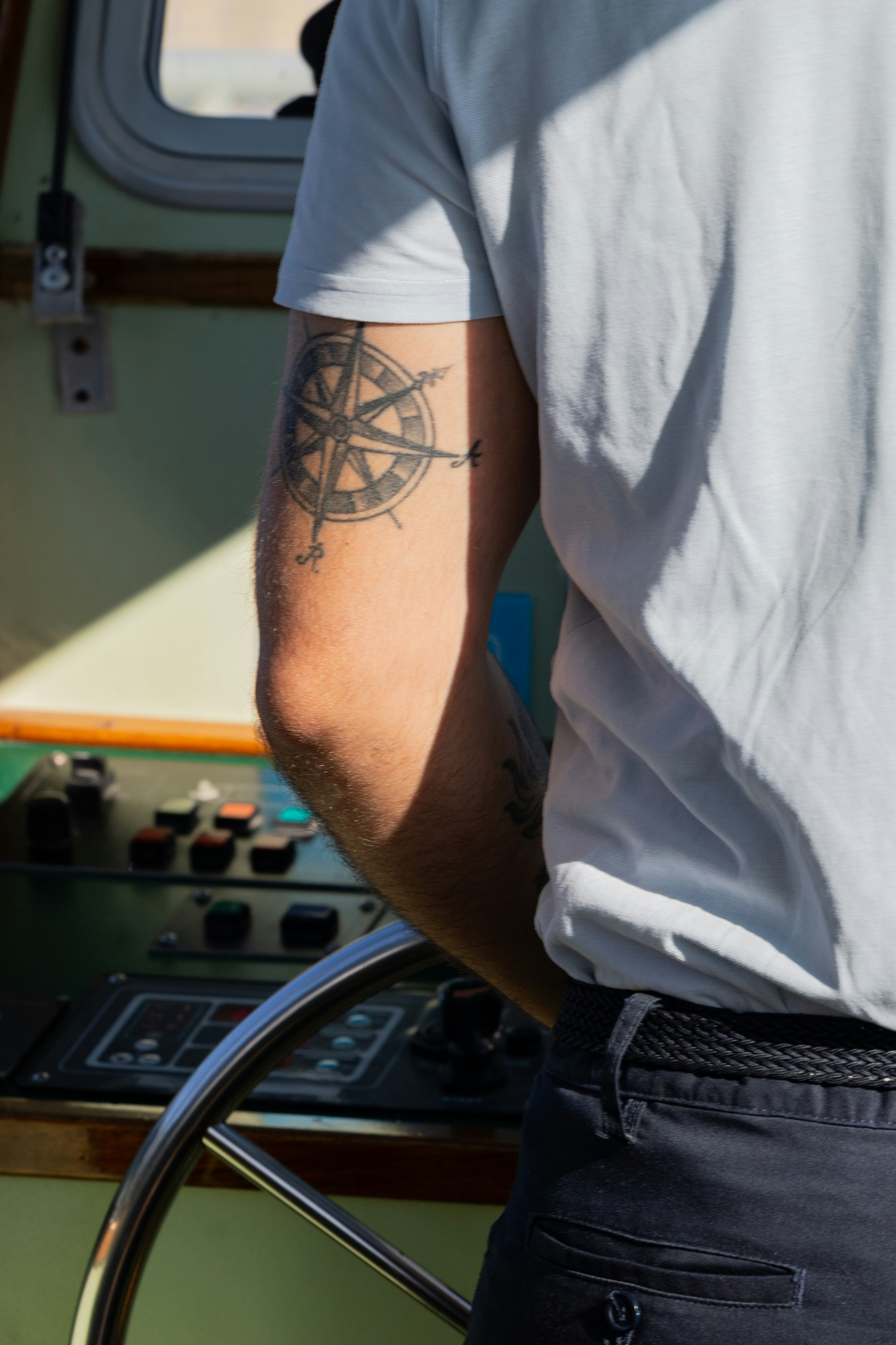 um homem com uma tatuagem de bússola no braço