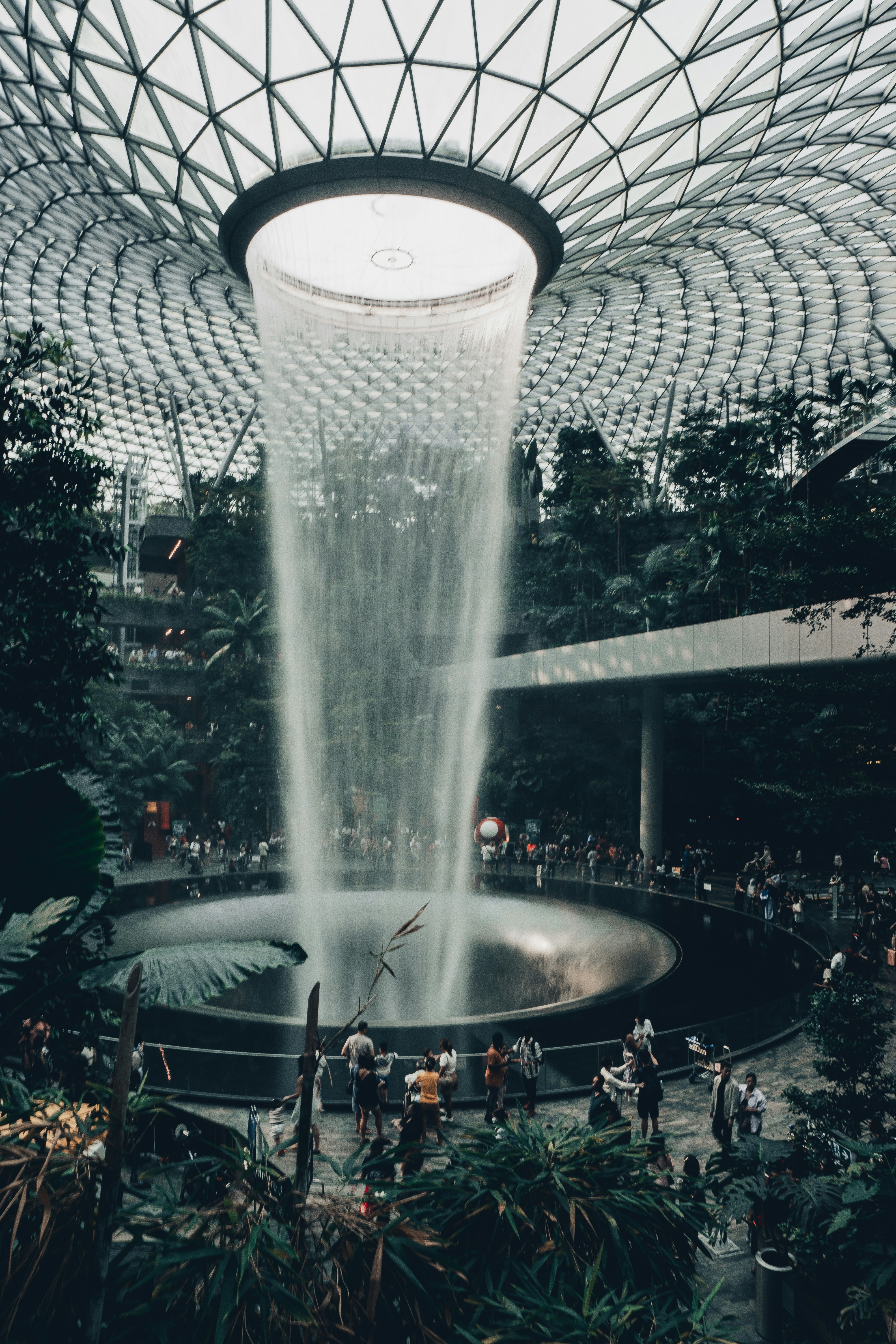 a large fountain in a building with people around it