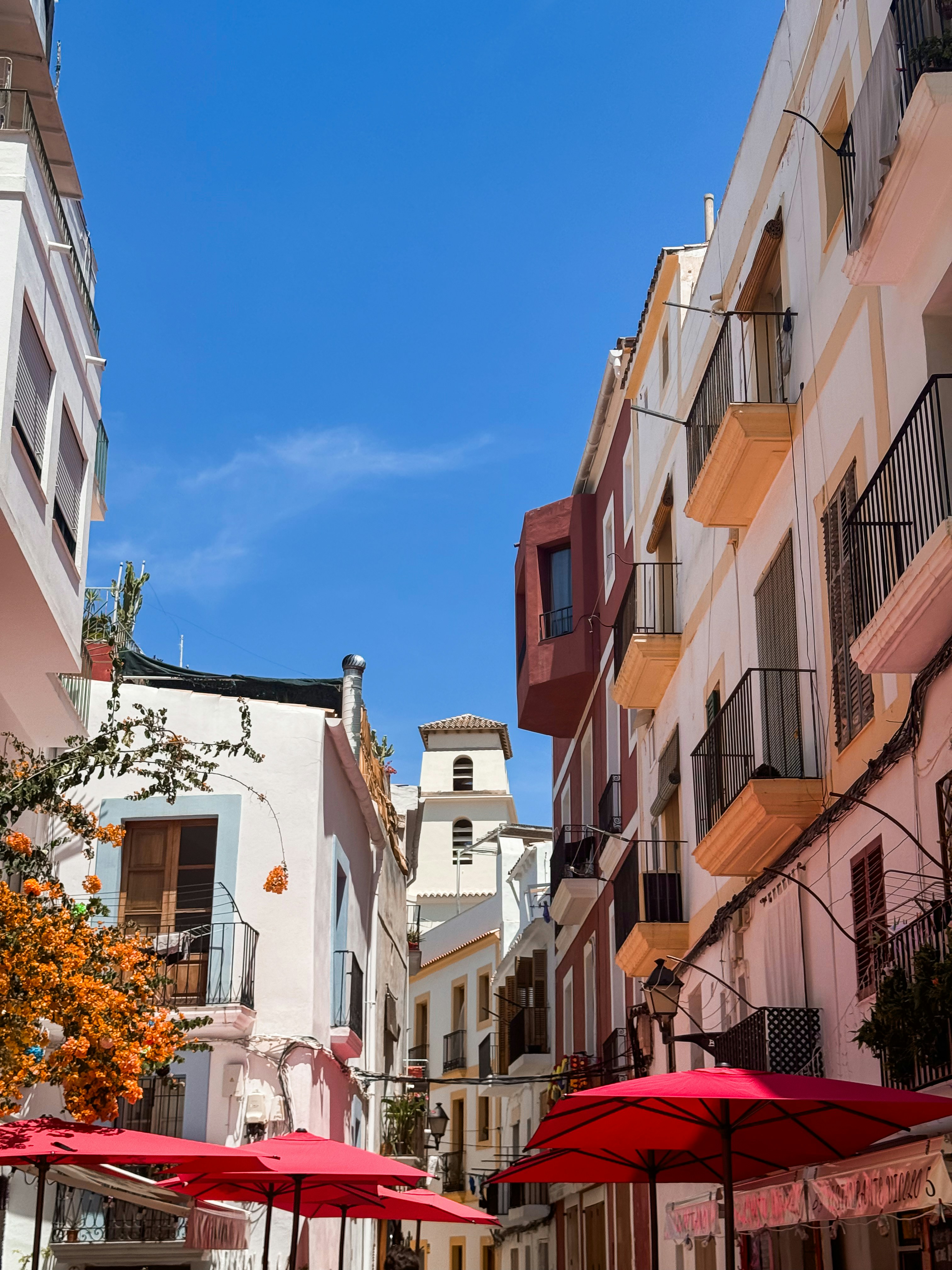 a group of red umbrellas sitting on the side of a street