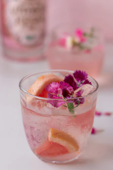 a glass filled with a drink and flowers