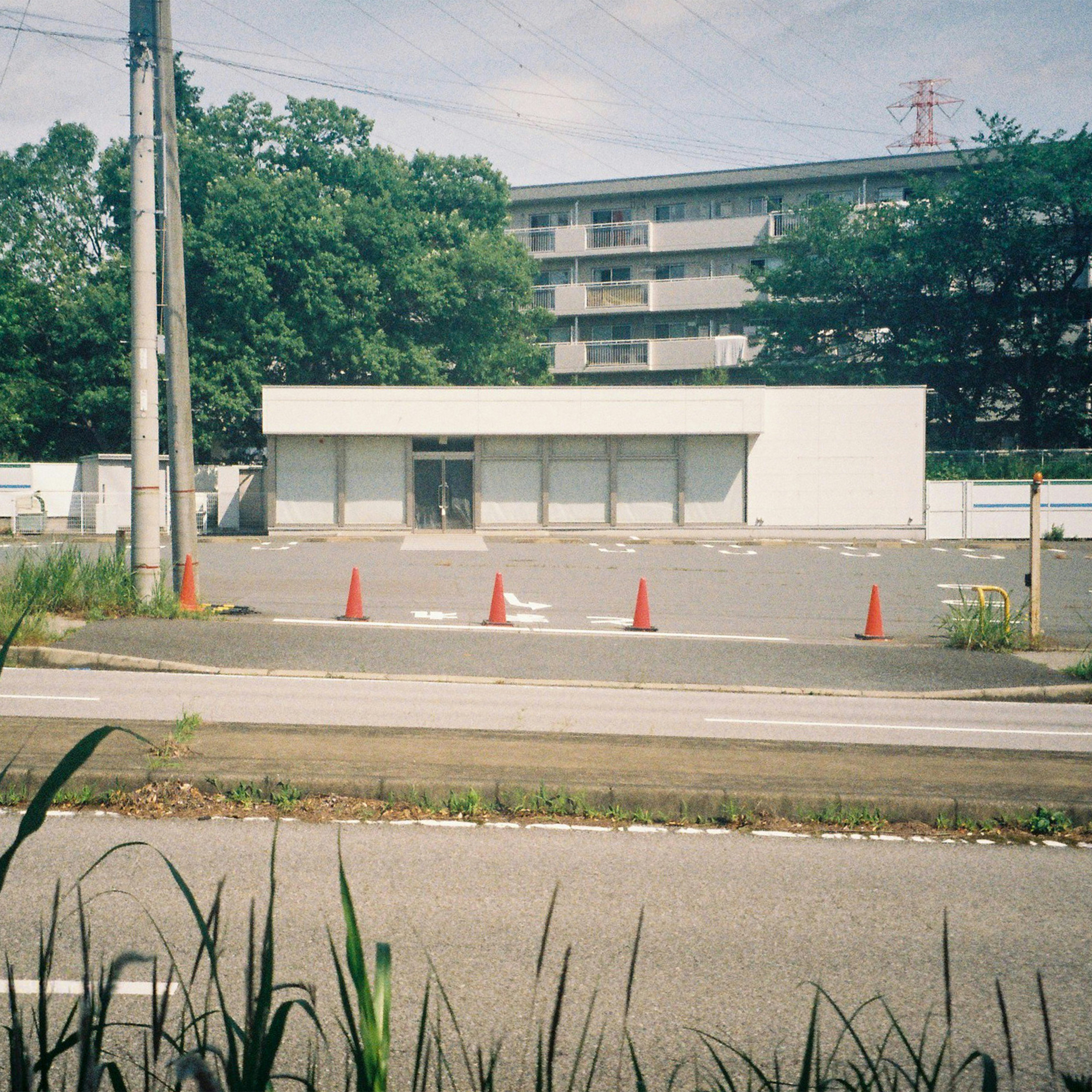 an empty parking lot with a building in the background
