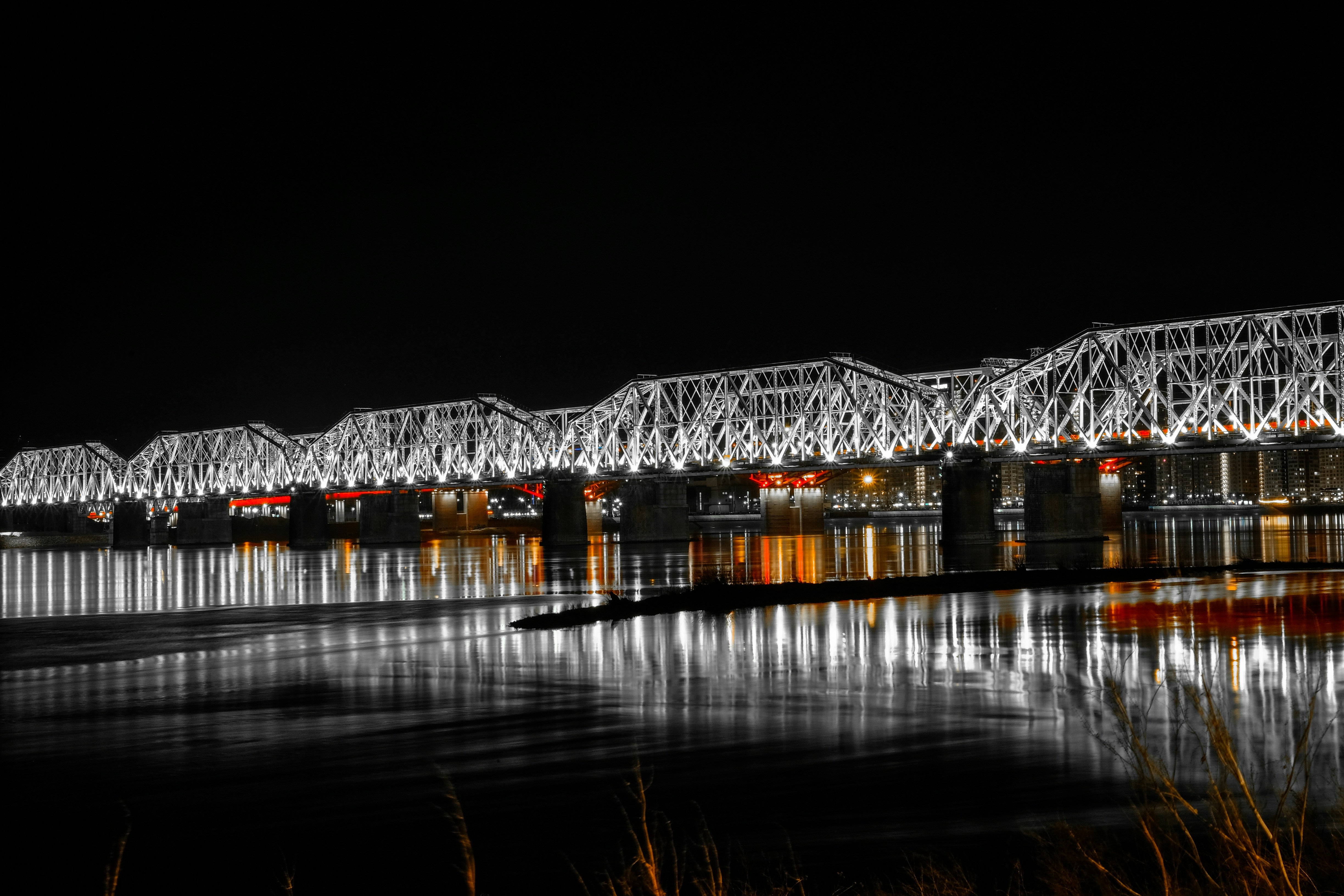 Eine große Brücke über ein Gewässer bei Nacht