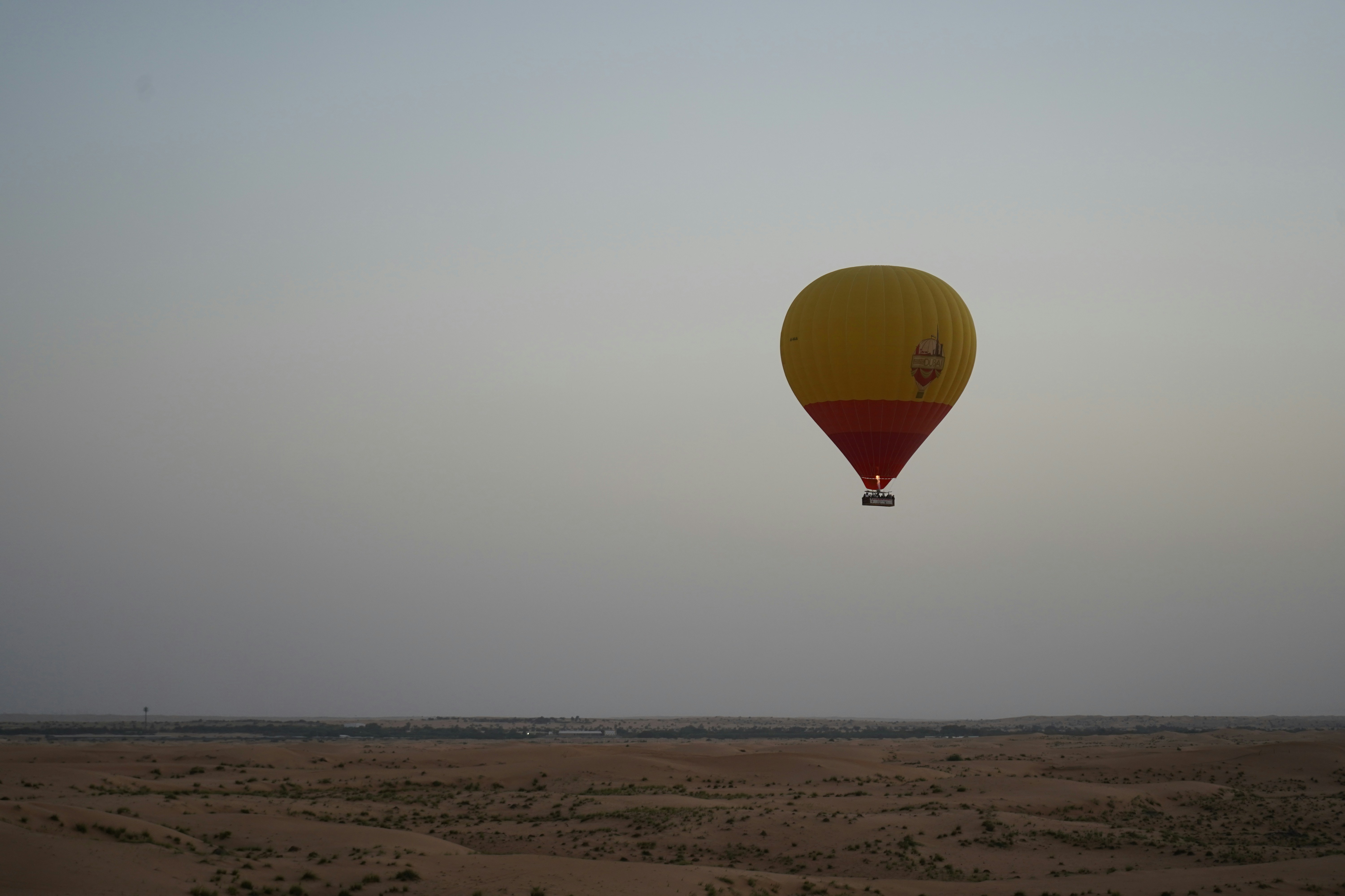 a yellow and red hot air balloon flying in the sky