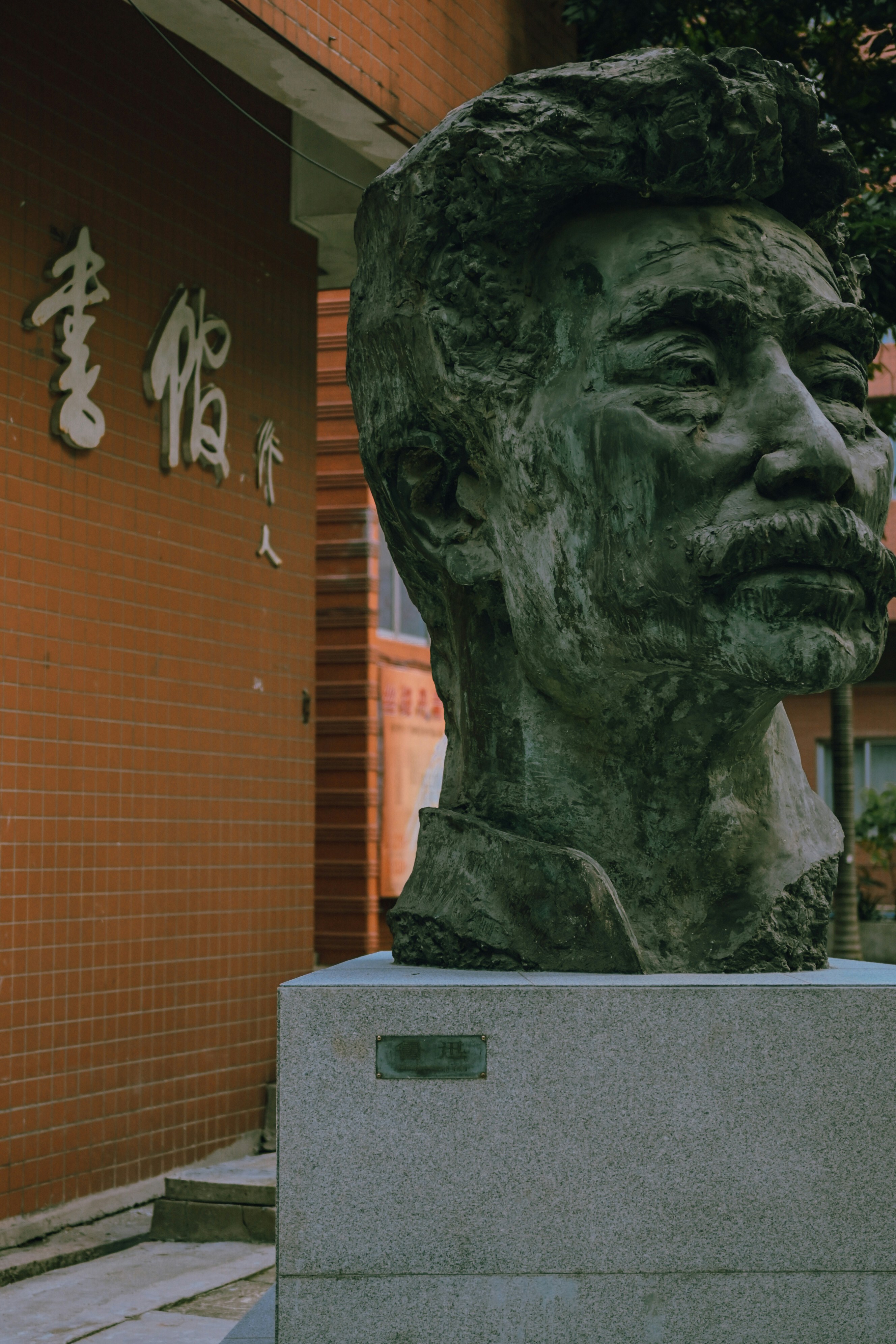 A statue of a man's head in front of a building photo – Free Art Image ...