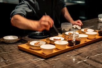 a person preparing food on a wooden tray