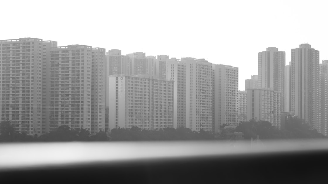 Dense residential apartment buildings with varied balconies stacked tightly together in an urban Vietnamese neighbourhood