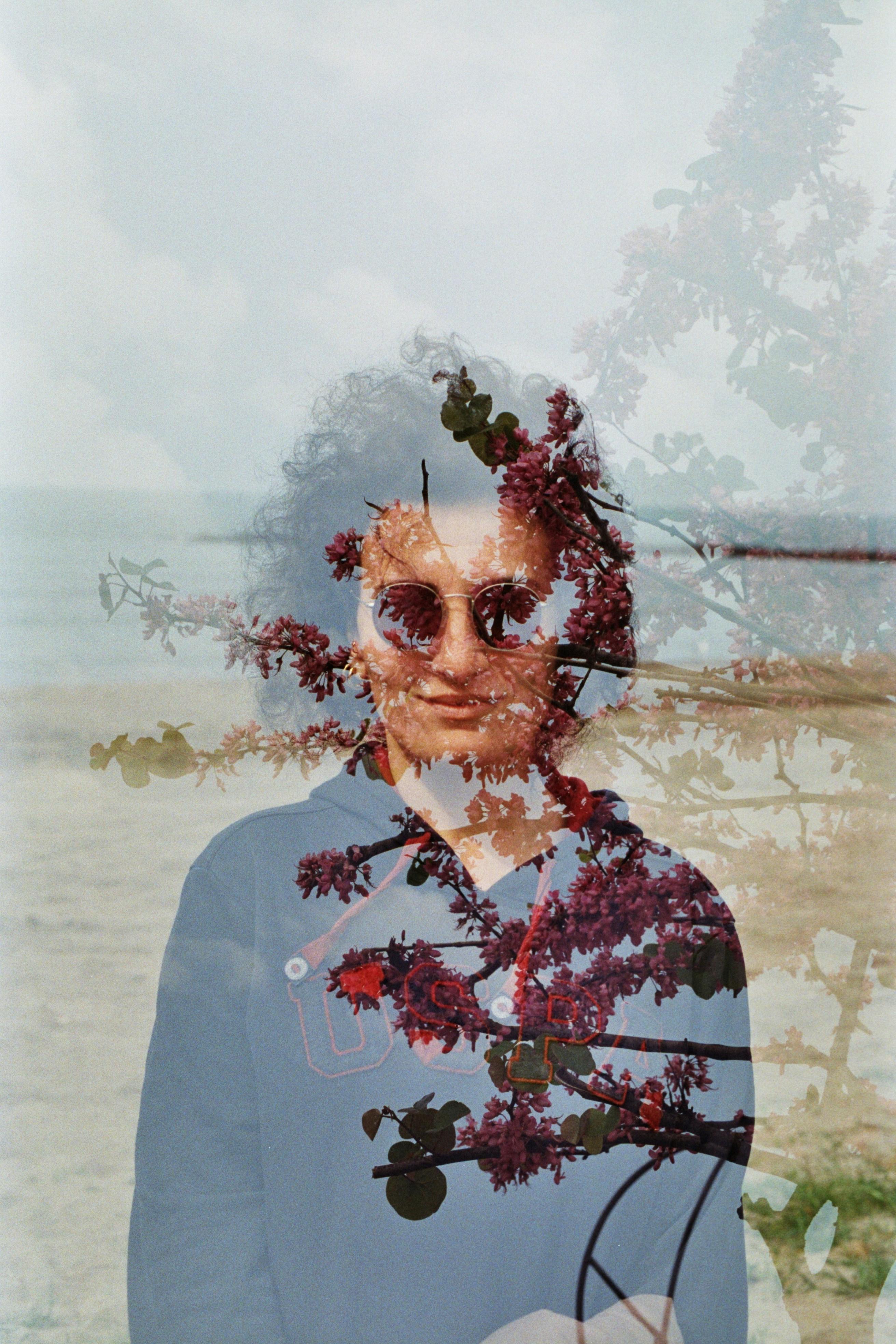 a man with sunglasses and a tree in the background