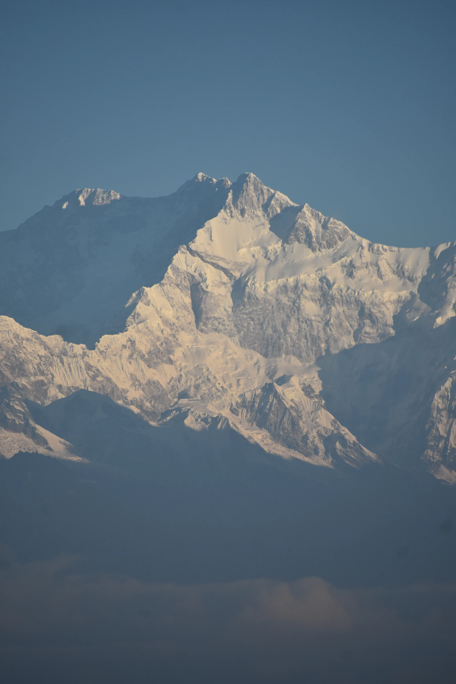 Kanchenjunga's summit ridges catching the early sun above the haze, seen from Tiger Hill near Darjeeling