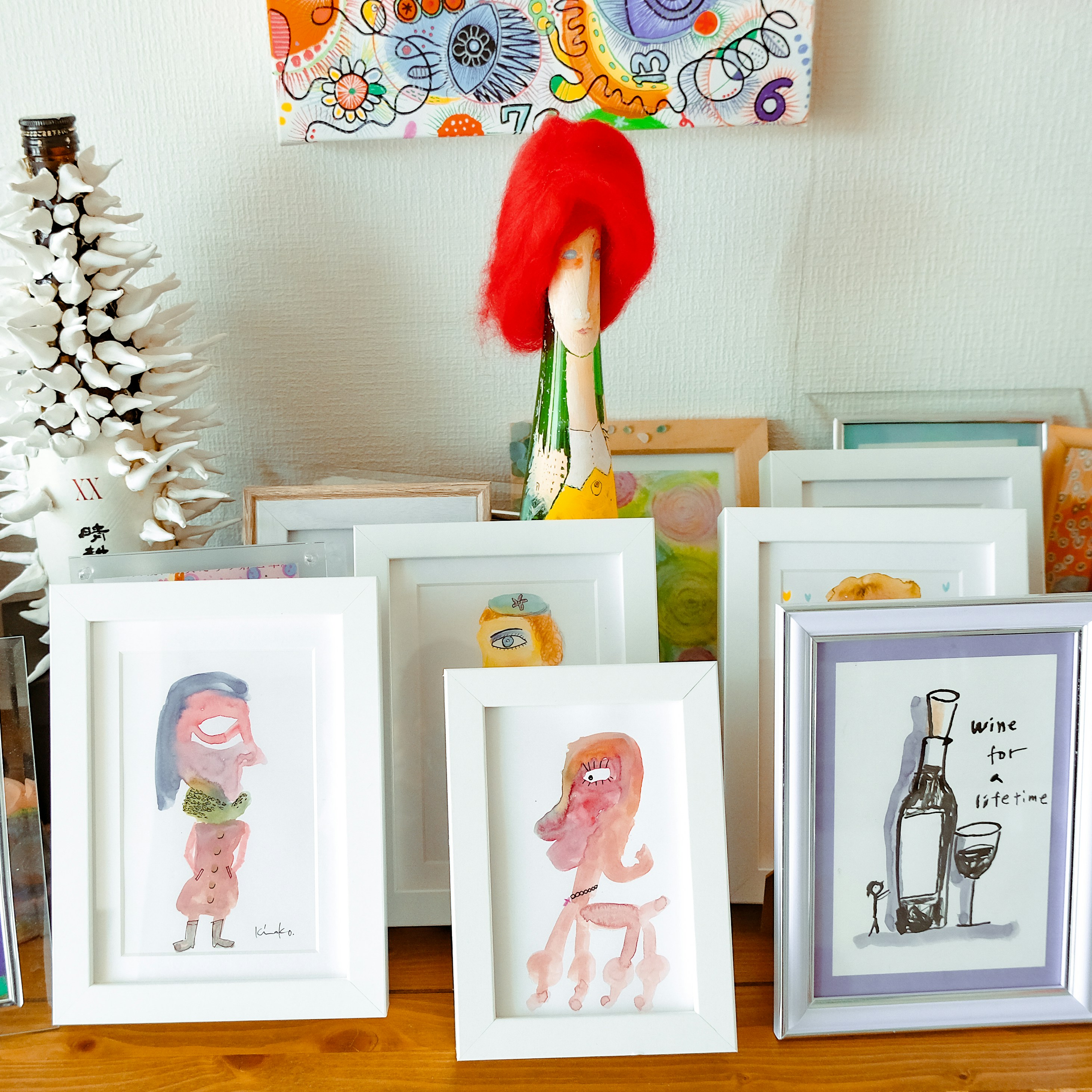 a group of framed pictures sitting on top of a wooden table