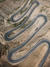 an aerial view of a winding road in the desert