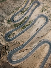 an aerial view of a winding road in the desert