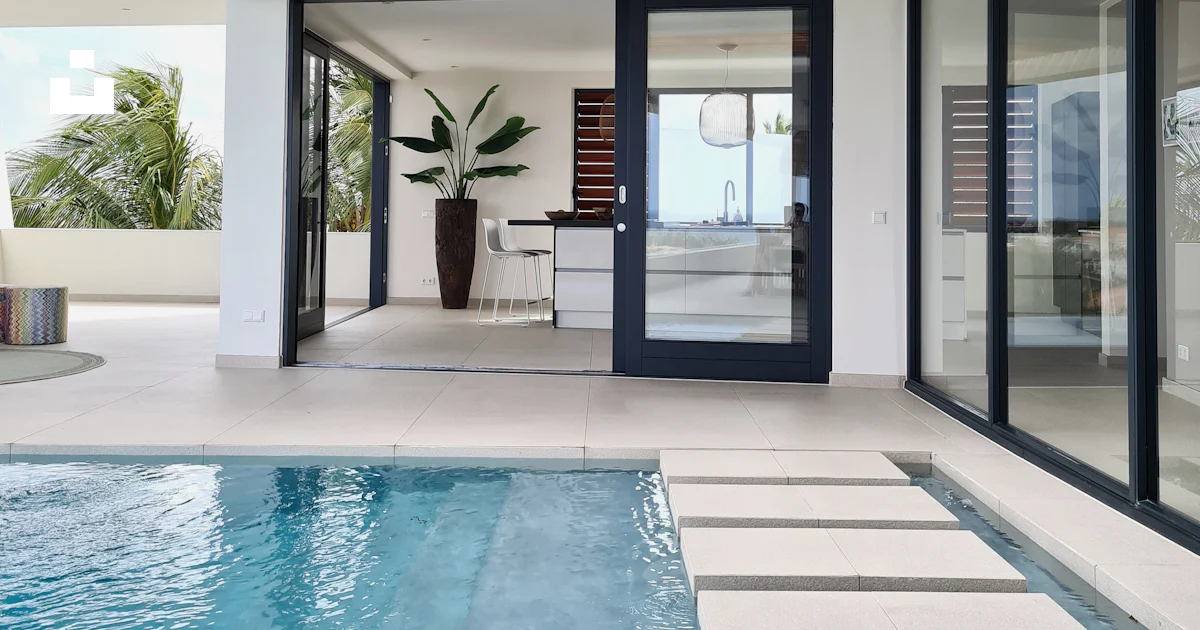 A swimming pool with a wooden ceiling and sliding glass doors photo ...
