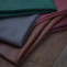 a pile of different colors of leather on a wooden floor