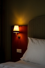 a bed with a lamp on the side of it
