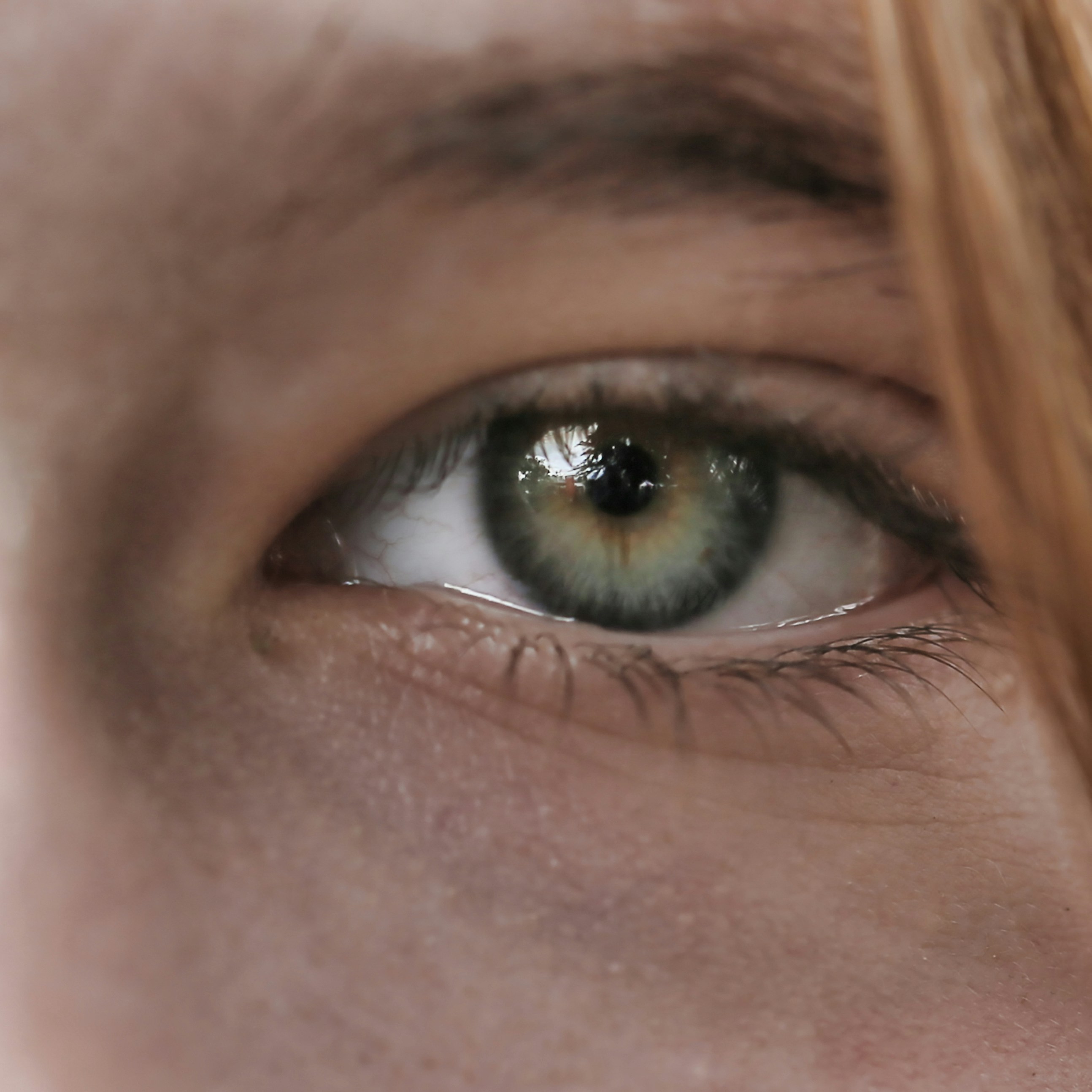 a close up of a person's green eye