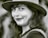 a black and white photo of a woman wearing a hat