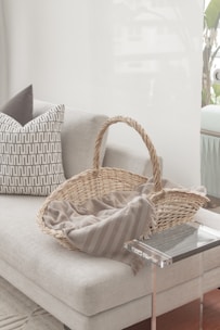 a wicker basket sitting on top of a white couch