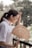 a woman standing on a balcony holding a fan