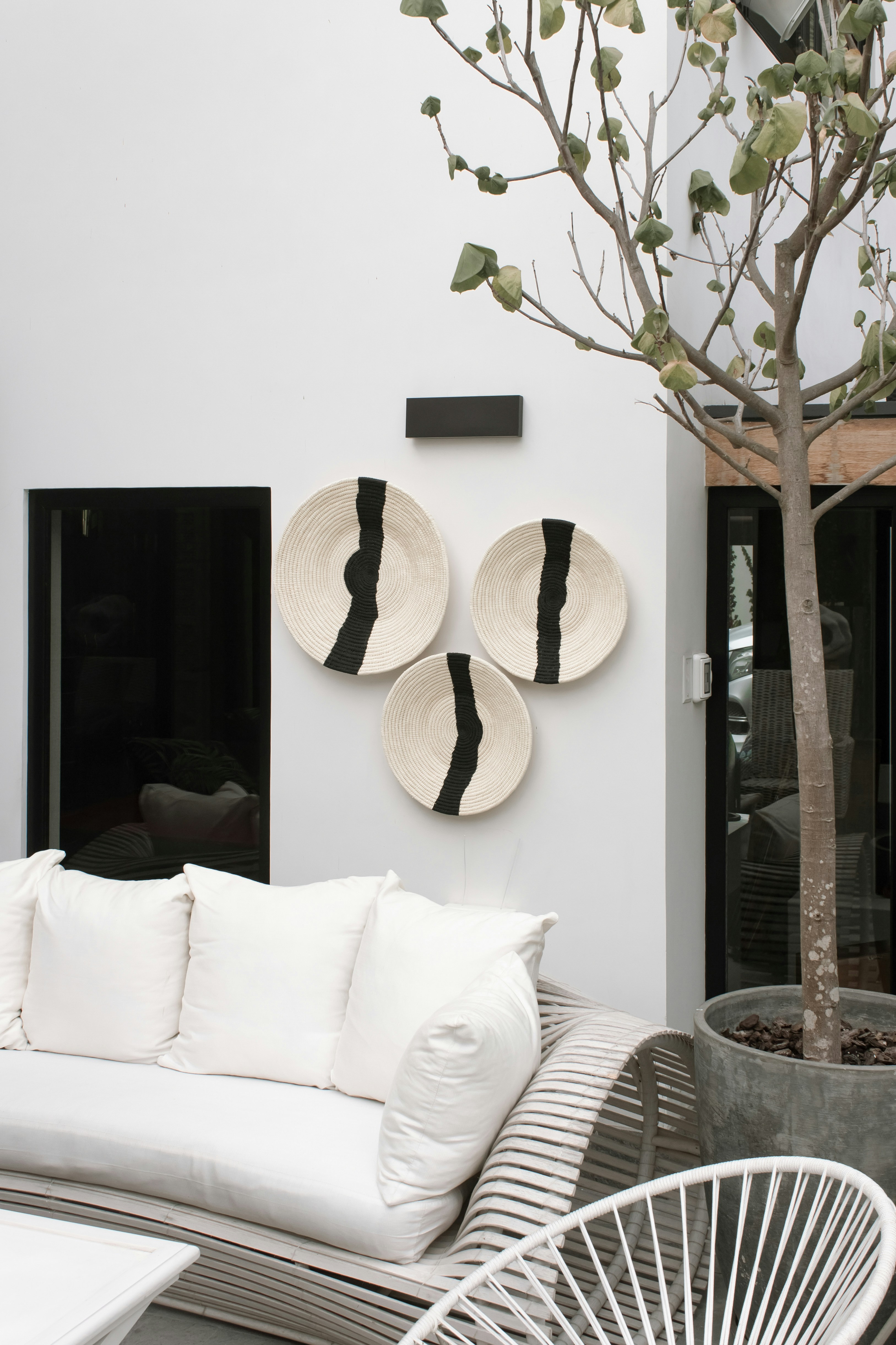 a white couch sitting next to a white tree