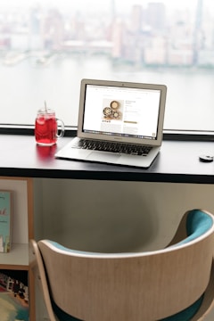 a laptop computer sitting on top of a wooden desk