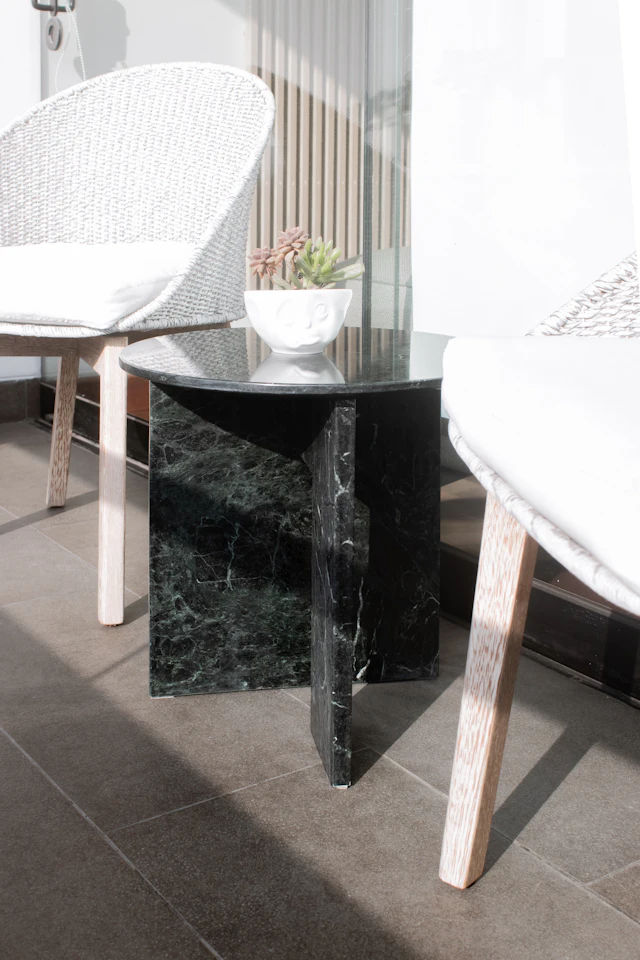 A black marble table with a white chair next to it