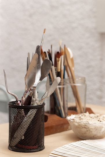 a cup filled with utensils on top of a wooden table