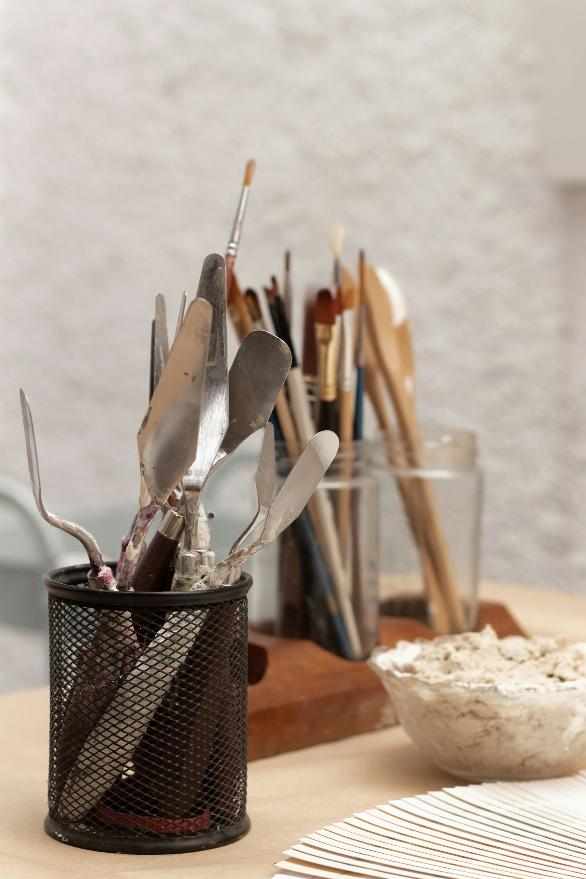a cup filled with utensils on top of a wooden table