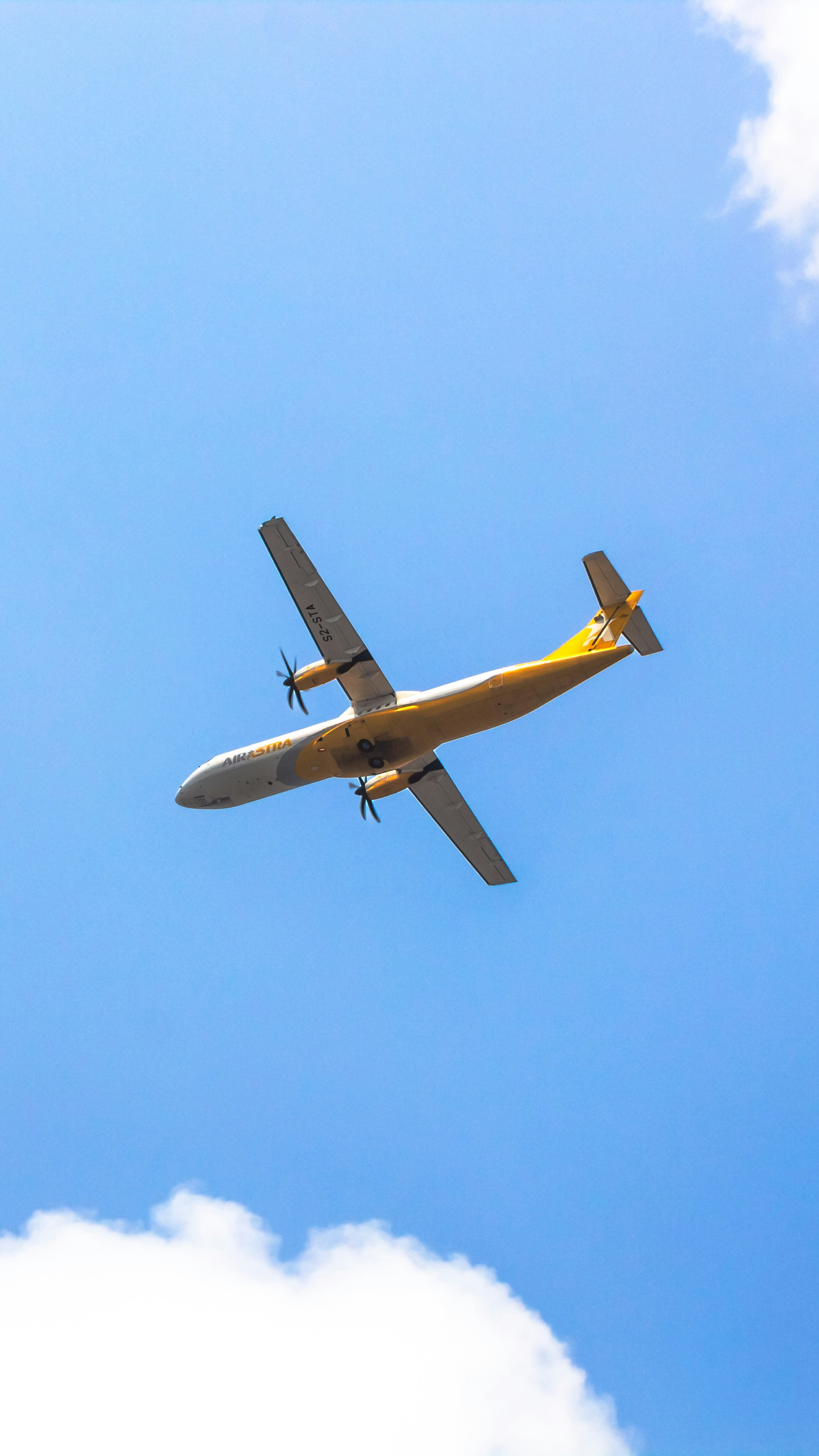 a large airplane flying through a blue sky