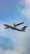 a large jetliner flying through a cloudy blue sky