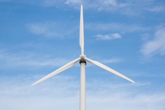 a white wind turbine against a blue sky