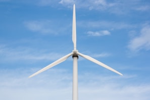 a white wind turbine against a blue sky