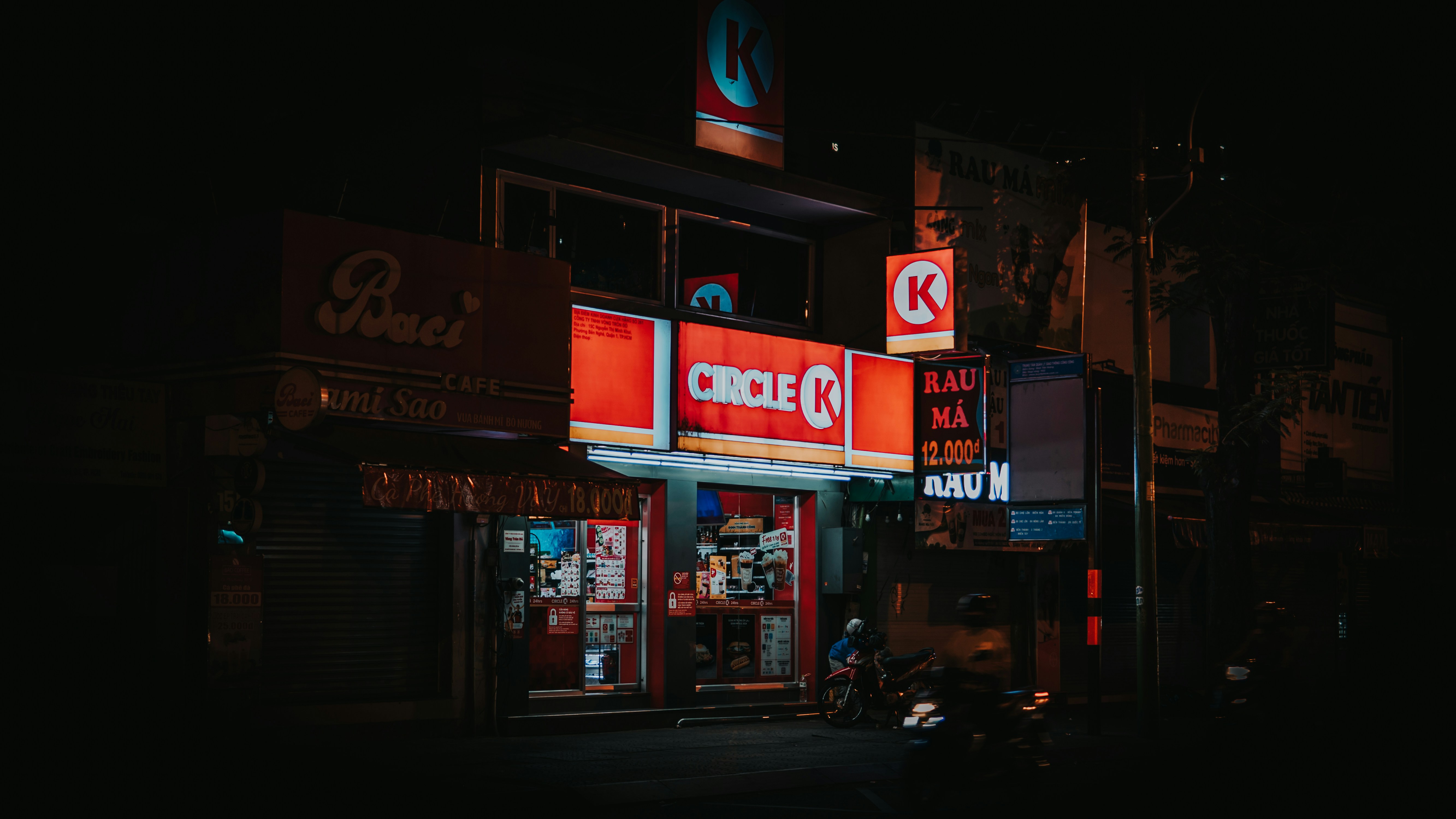 a store front at night with neon signs